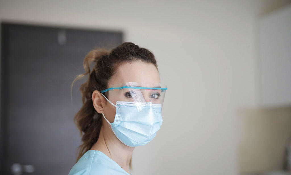 healthcare worker in face mask and shield